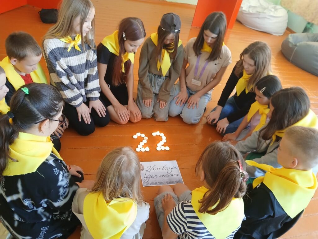 Дети выложили из свечей цифру 22 и почтили память погибших минутой молчания.